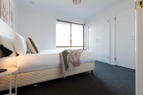1 dormitorio con cama y ventana grande en 3 Bedroom Home: Parking & WiFi en Kings Meadows