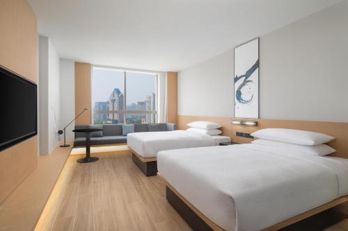 a hotel room with two beds and a flat screen tv at Fairfield by Marriott Hangzhou Wulin Square, China in Hangzhou