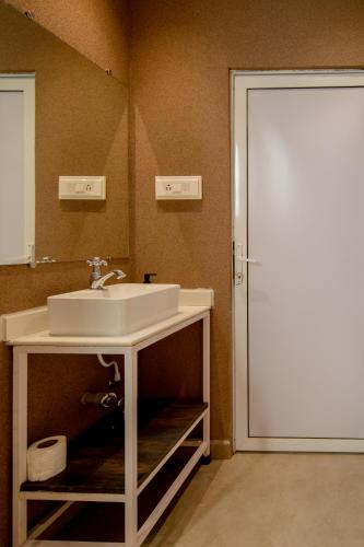 uma casa de banho com um lavatório e um espelho em Abalone 6 BHK Villa by Stayscape em Kīhīm