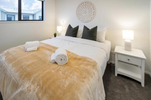a bedroom with a large white bed with towels on it at Beachside Haven 1 bed 1 bath in Christchurch
