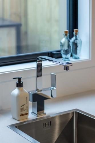 a bathroom sink with a bottle of soap on it at Beachside Haven 1 bed 1 bath in Christchurch