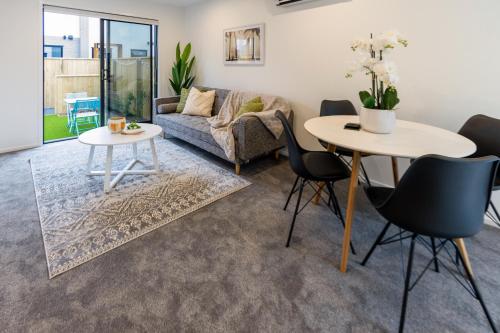 a living room with two tables and a couch at Beachside Haven 1 bed 1 bath in Christchurch