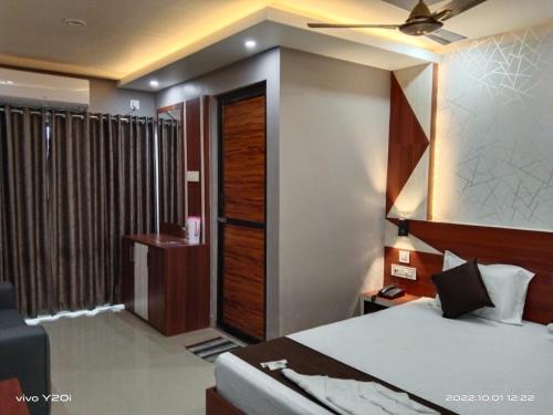 a hotel room with a bed and a window at Hotel Marine Blue in Digha