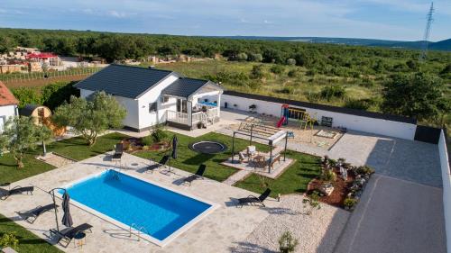 an aerial view of a house with a swimming pool at Holiday home Aprilis with pool, jacuzzi and sauna in Galovac