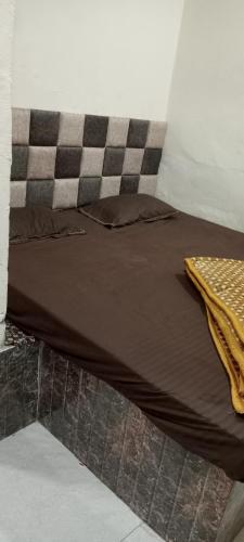 a bed in a room with a checkeredkered at Shree maya home stay in Ujjain