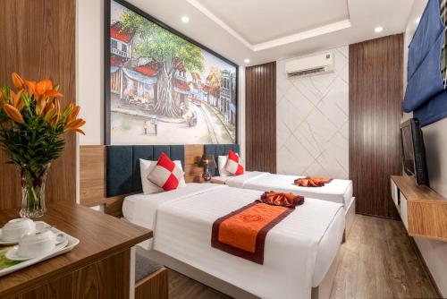 a hotel room with two beds and a tv at Aquarius Grand Hotel in Hanoi