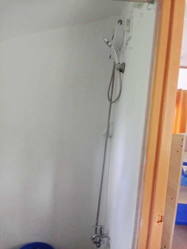 a room with a white wall with a shower at Bayay ni Nanay Bed & Breakfast in Magpupungko Beach Road in Pilar
