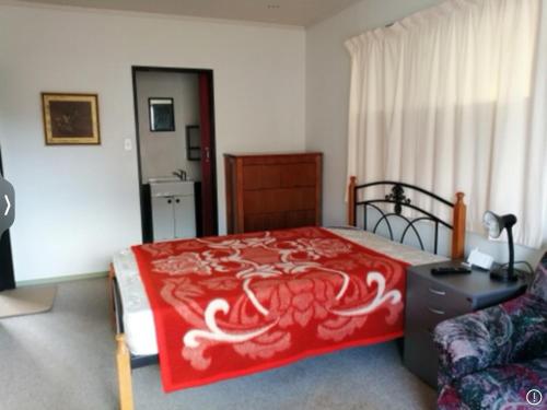 Un dormitorio con una cama con una manta de dragón rojo en 驿站, en Auckland