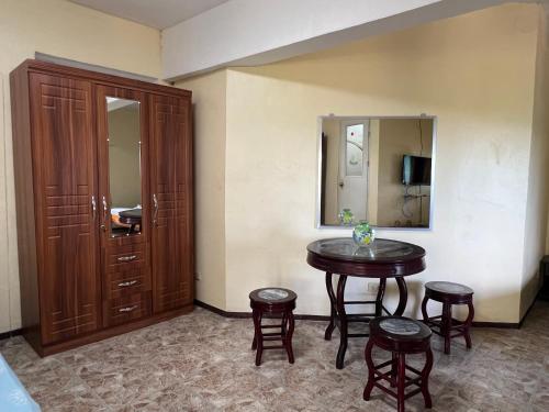 Cette chambre comprend une table, des tabourets et un miroir. dans l'établissement Bamboo Paradise Beach Resort, à Argao