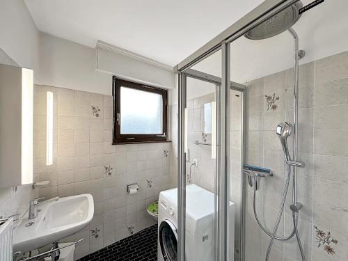 une salle de bain avec douche et lavabo et une machine à laver dans l'établissement Instant Ski and Golf Paradise - Crans Montana, à Crans-Montana