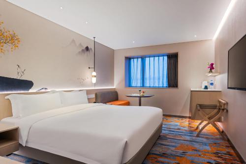 a hotel room with a white bed and a window at Sunworld Hotel Wangfujing in Beijing