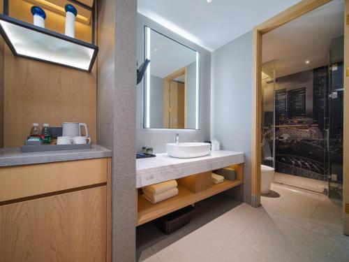 a bathroom with a sink and a mirror at Park Inn by Radisson Chengdu Wuhou Shrine in Chengdu