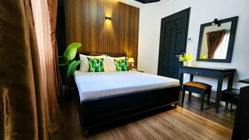 a bedroom with a bed with a desk and a mirror at Rosa May Hotel in Ho Chi Minh City