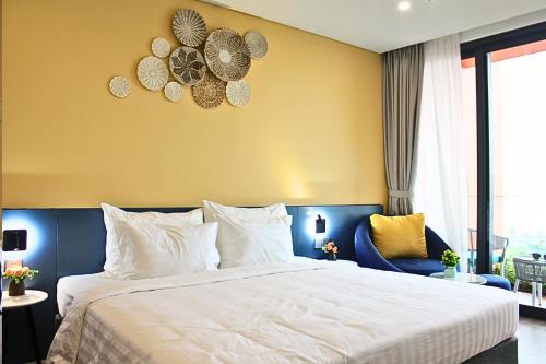 a bedroom with a large bed and a yellow wall at Flamingos Hải Tiến in Nam Khê