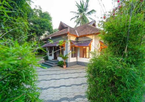 a small house with a tiled roof at Pop Tavern Kovalam Beach Villa by VOYE HOMES in Kovalam