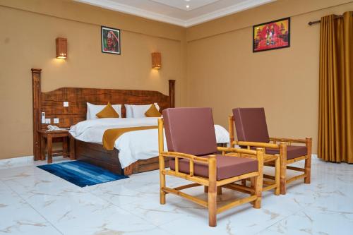 1 Schlafzimmer mit einem Bett und 2 Stühlen in der Unterkunft Sogakope Beach Resort & Spa in Sogakofe