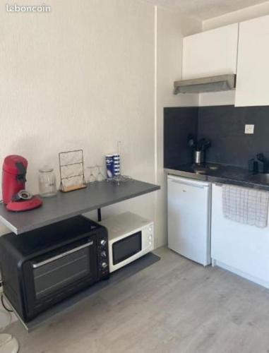 La cuisine est équipée d'un four micro-ondes et d'un comptoir. dans l'établissement Appartement Studio Cabine Plage, à La Grande Motte