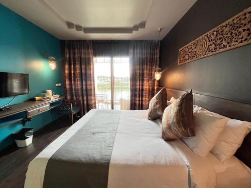 Ein Bett oder Betten in einem Zimmer der Unterkunft Chiangkhong Teak Garden Riverfront Onsen Hotel- SHA Extra Plus