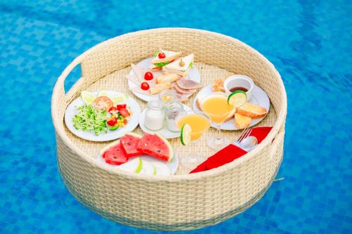 a basket filled with food and drinks next to a pool at 22Land Residence Hotel & Spa Ha Noi in Hanoi