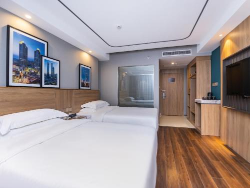 a hotel room with two beds and a flat screen tv at Country Inn&Suites by Radisson, Shanghai PVG in Shanghai