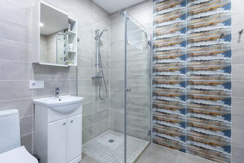 a bathroom with a shower and a toilet and a sink at Amber - Luxury Two Bedroom Apartment in Palanga