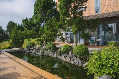 a pond in front of a house with ducks in it at SEN VILLA Boutique in Bao Loc