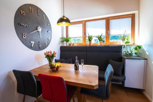 a dining room with a table and a clock on the wall at Ferienwohnung Kirchmair in Kirchdorf in Tirol