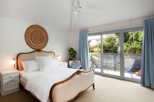 sypialnia z łóżkiem i przesuwnymi szklanymi drzwiami w obiekcie The Bronte Breeze w mieście Sydney