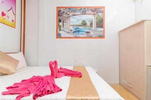 um cobertor rosa sentado em cima de uma cama em Motel Hoài An em Can Tho