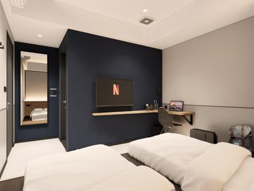 a bedroom with two beds and a tv on the wall at FIERIS IZZY Hotel in Jakarta
