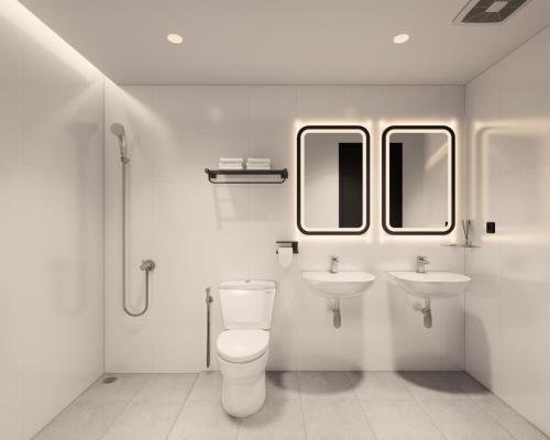 a white bathroom with a toilet and two sinks at FIERIS IZZY Hotel in Jakarta