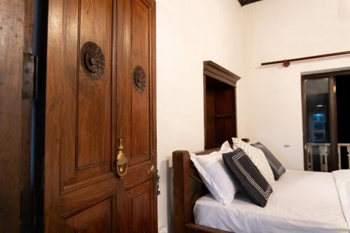 a bedroom with a bed and a wooden door at Beragala Serene Villa in Beragala