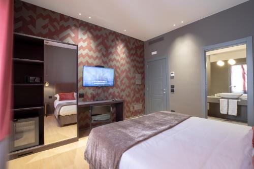 1 dormitorio con 1 cama y TV en la pared en Re Sale Boutique Hotel en Trapani