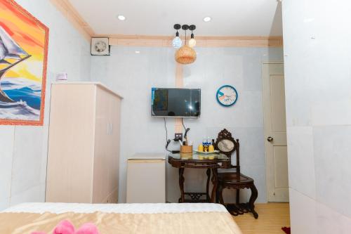 sypialnia z łóżkiem, stołem i telewizorem w obiekcie Motel Hoài An w mieście Cần Thơ