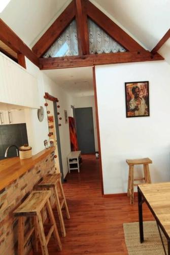 - une cuisine avec des tables et des tabourets en bois dans une chambre dans l'établissement Appartement en plein cœur de ville, à Perros-Guirec