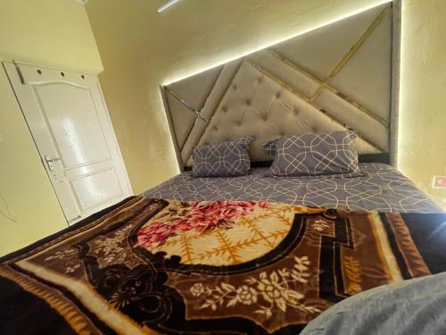 Una cama en una habitación con colcha. en Mannat Manzil en Lucknow