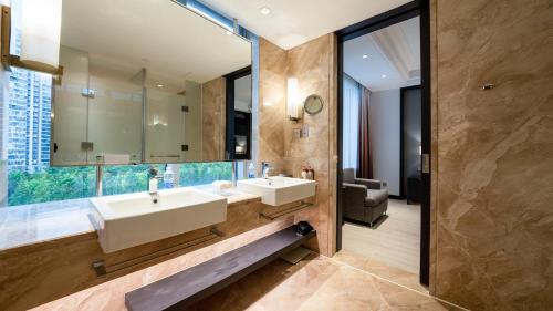 ein Bad mit einem Waschbecken und einem Spiegel in der Unterkunft Crowne Plaza Shanghai Anting, an IHG Hotel - 15 minutes drive to FE in Jiading