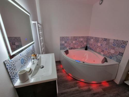 een witte badkamer met een bad en een wastafel bij Le St Gildard in Nevers