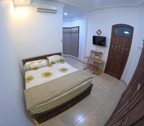 ein Schlafzimmer mit einem Bett und einem TV in der Unterkunft Griya Giwangan Homestay Jogja in Timuran