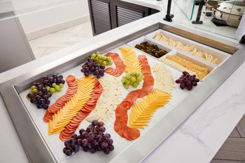 a platter of food with cheese and grapes at Staybridge Suites Silicon Valley - Milpitas by IHG in Milpitas