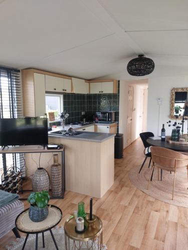 a kitchen and living room with a table and chairs at Camping 't Venhop in Berkhout