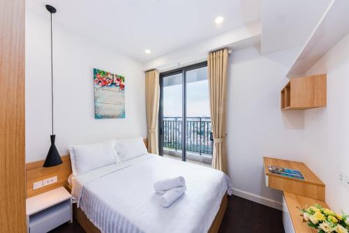 - une chambre avec un lit et une grande fenêtre dans l'établissement Bumble Apartment, à Hô-Chi-Minh-Ville