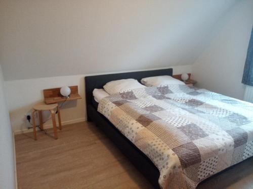una camera con un letto con una trapunta sopra di Haus Wattenblick OG a Morsum