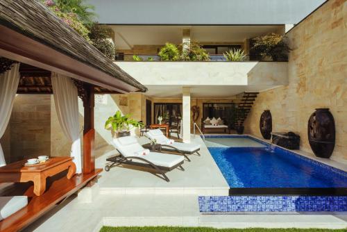 a house with a swimming pool and a patio at Viceroy Bali in Ubud