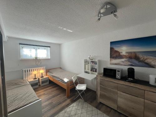 Habitación con 1 dormitorio con 1 cama y TV. en 1-Raum Ferienwohnung Souterrain Niederorschel en Niederorschel