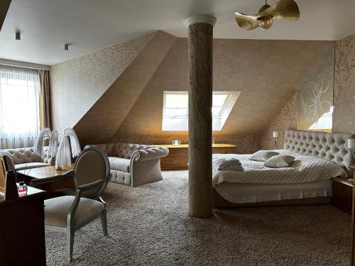 sypialnia z łóżkiem i kolumną w obiekcie Hotel Badura w Wadowicach