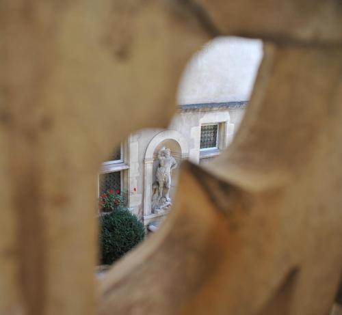 a view of a statue through a wooden fence at Hotel D'haussonville in Nancy