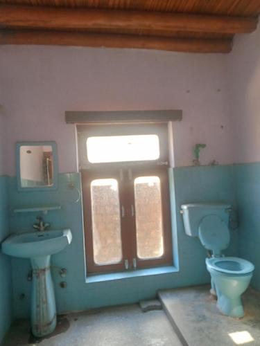 a bathroom with a sink and a toilet and a window at Abbreviate guest house in Leh