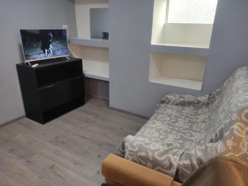 sala de estar con sofá y TV en Small Home, en Chişinău