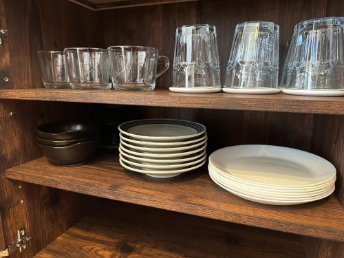 a bunch of plates and glasses on a shelf at Hotel Dios - Vacation STAY 31184v in Awaji